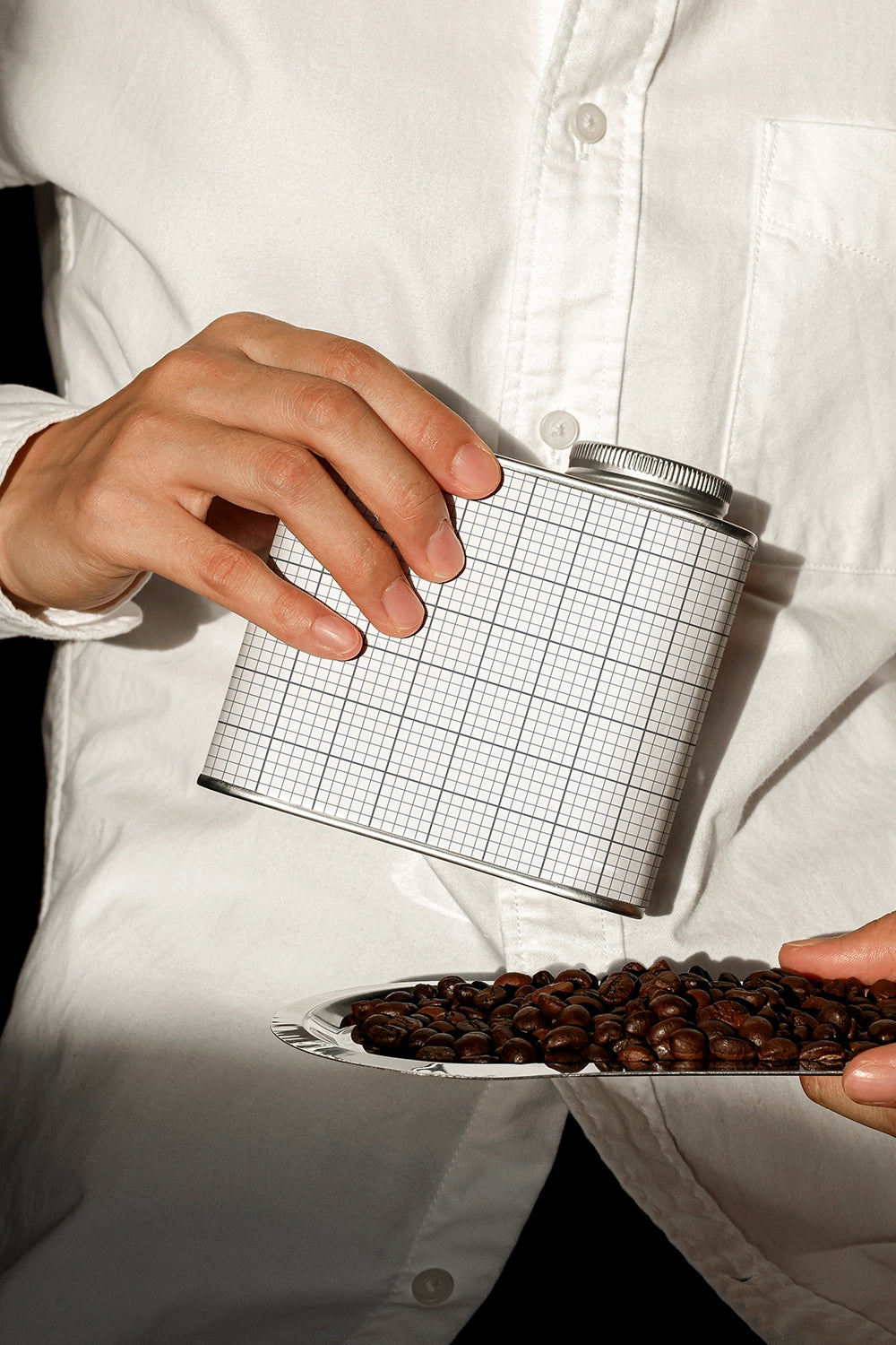 coffee tin packaging mockup with pouring beans action, minimal and realistic presentation