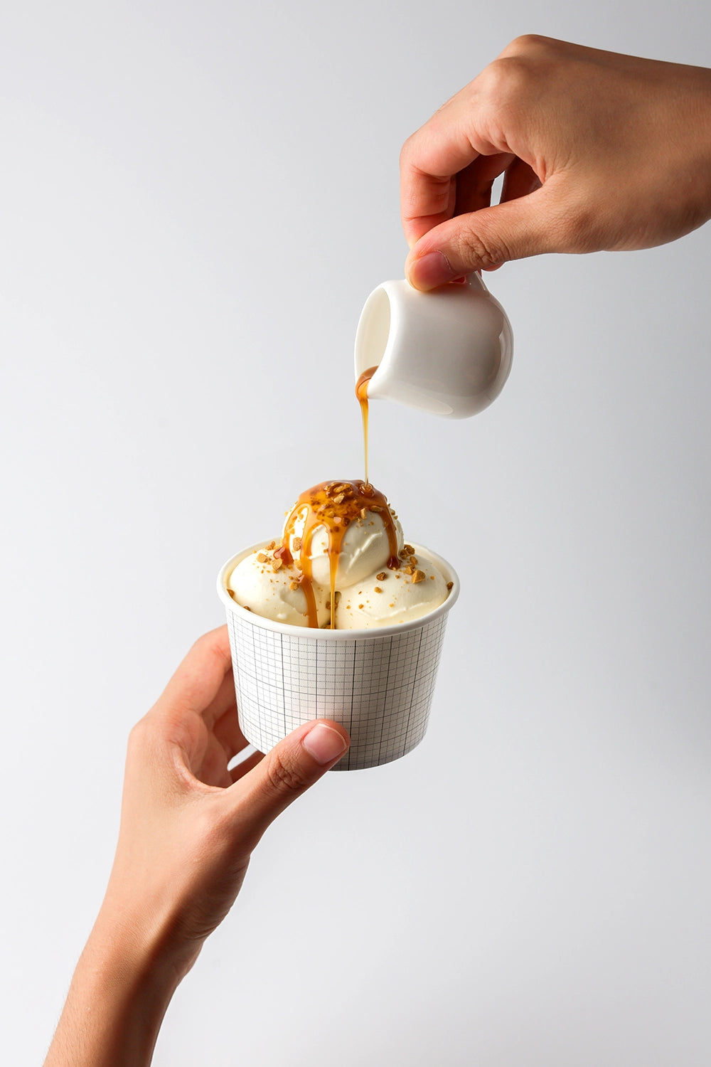 Ice cream packaging mockup with caramel drizzle and realistic food styling in hand