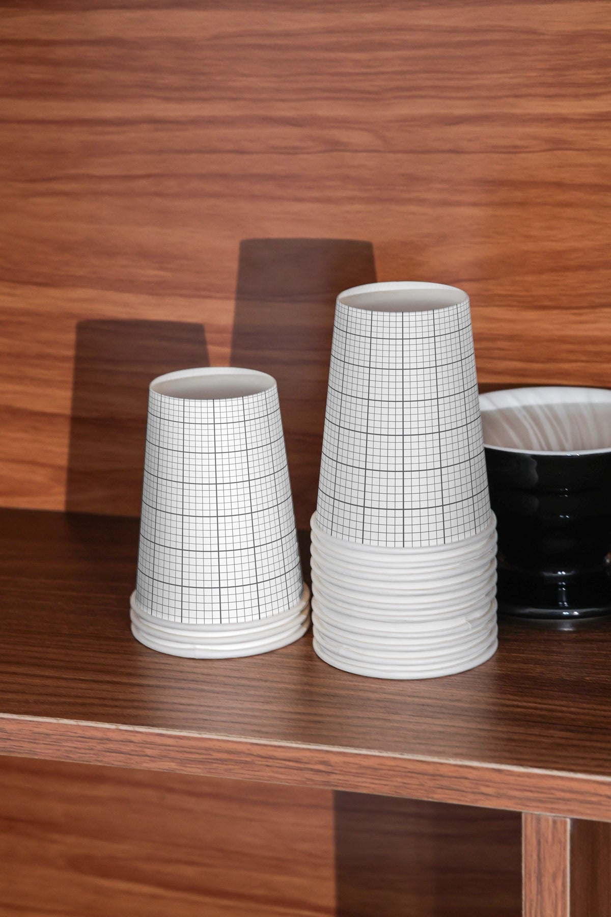 paper coffee cups mockup stacked upside down on wooden surface, minimal branding presentation