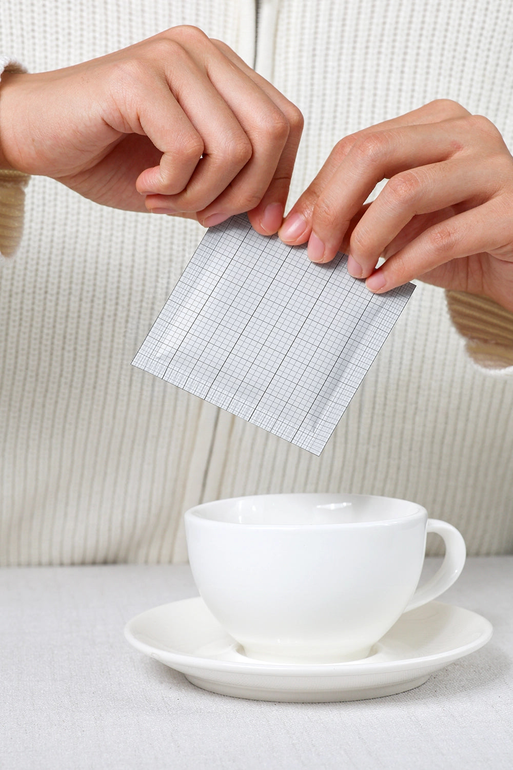 sachet mockup in use with cup and hands demonstrating product application