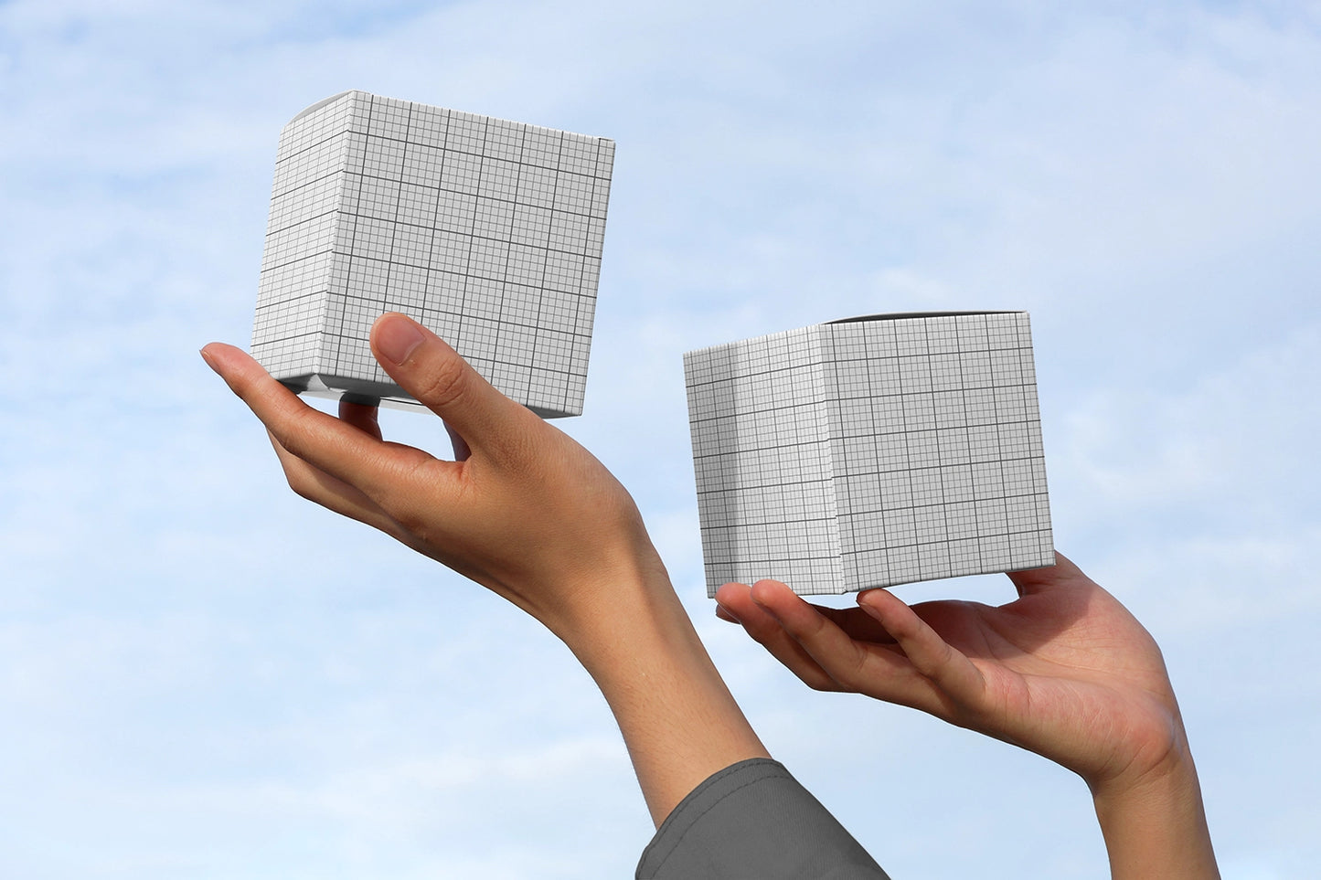 Product box mockup with two cube boxes in hands with clean sky backdrop