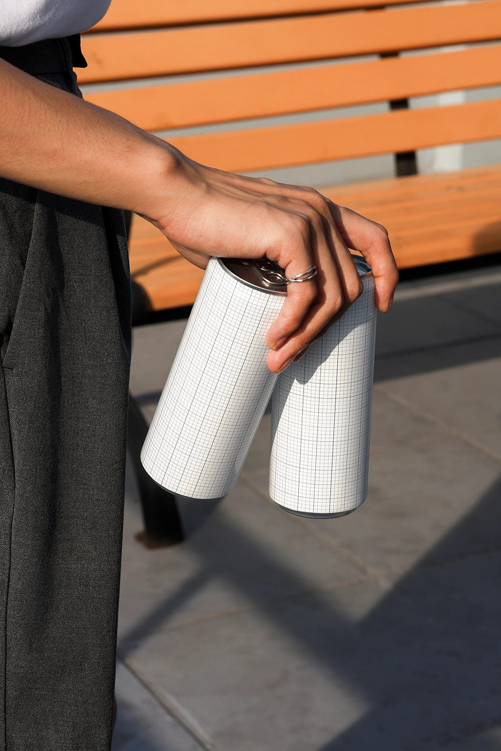 Two aluminum beverage cans mockup with casual hand holding for soda and energy drink branding