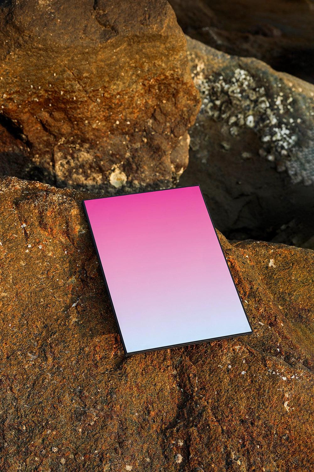 realistic poster mockup placed on stone background with golden hour lighting and natural texture