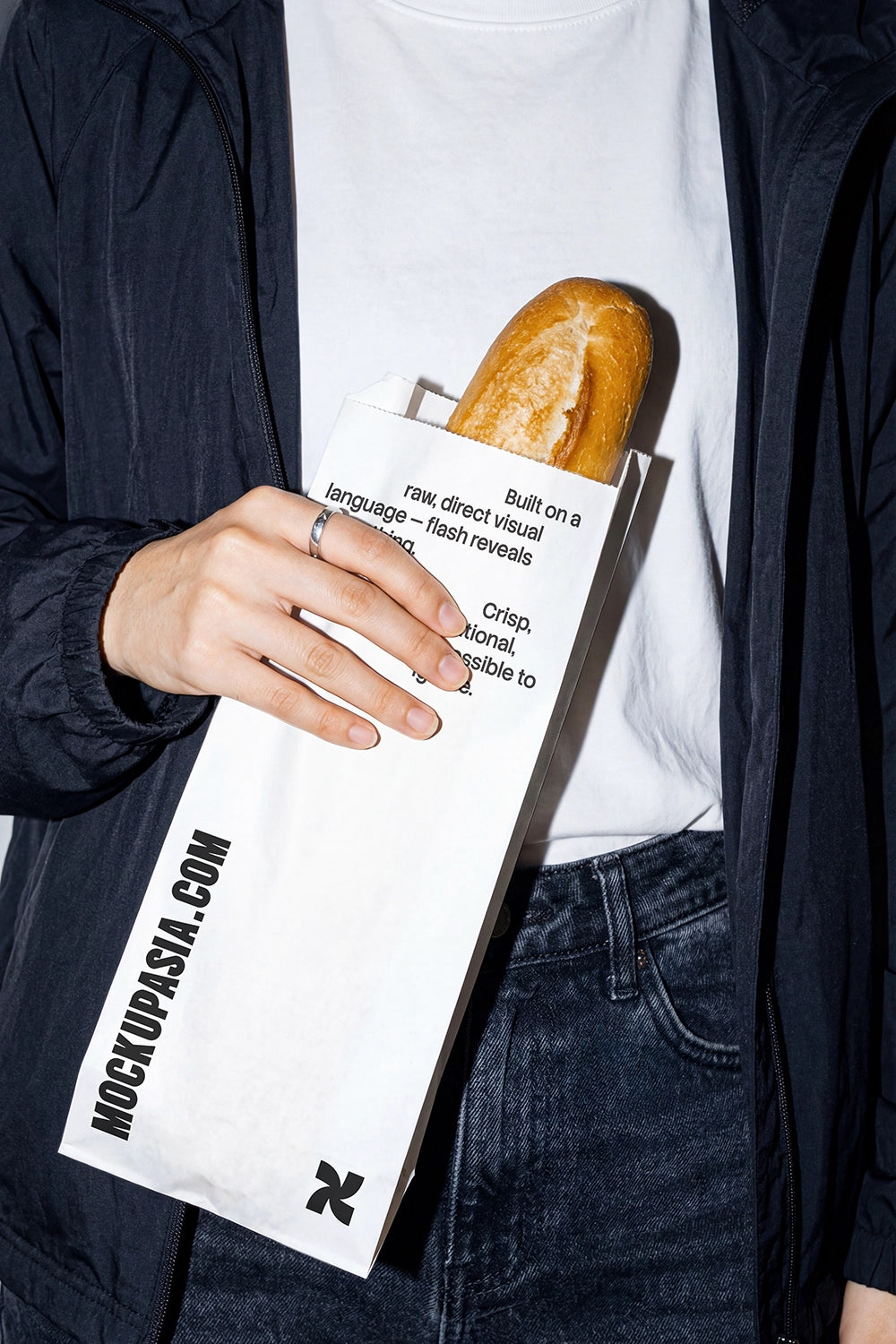 bakery paper bag mockup with baguette in hand high contrast flash lighting