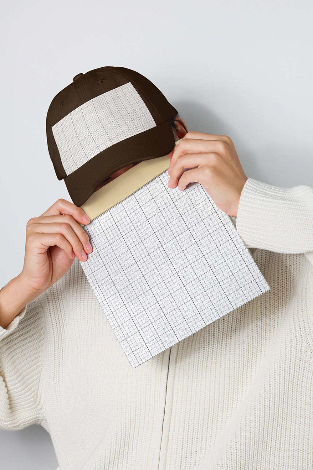 baseball cap mockup with grid panel held in hands and minimal neutral background