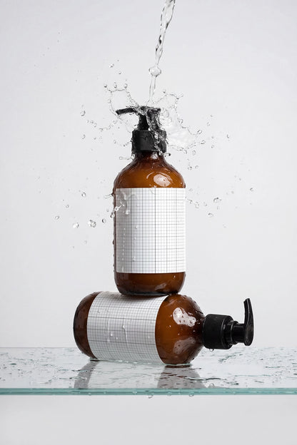 Personal care bottle PSD mockup with two amber pump bottles and water splash.