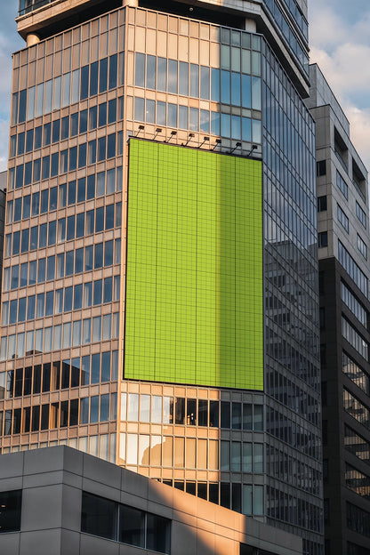 vertical OOH billboard mockup on high-rise building with golden hour lighting