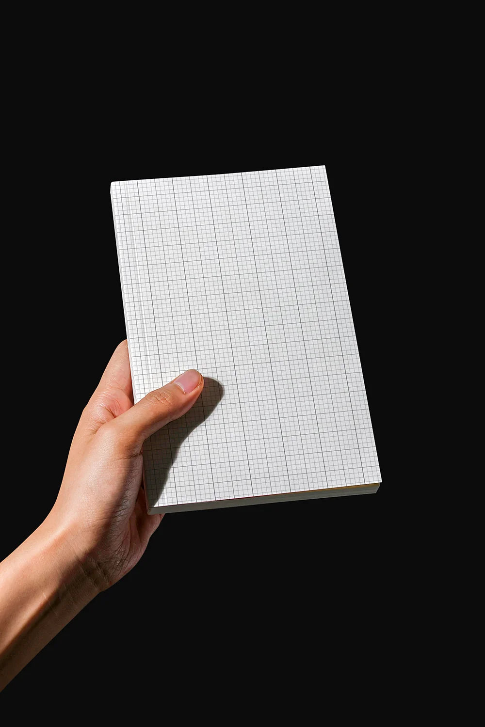 book cover mockup in hand with strong contrast lighting, modern branding display