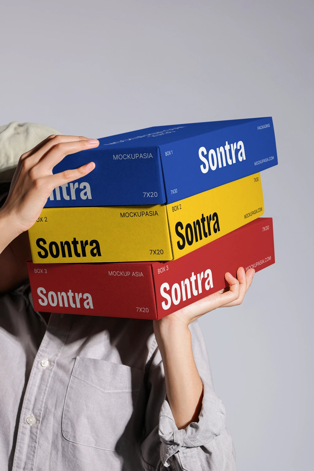 Packaging box mockup with white green and pink boxes in handheld branding presentation