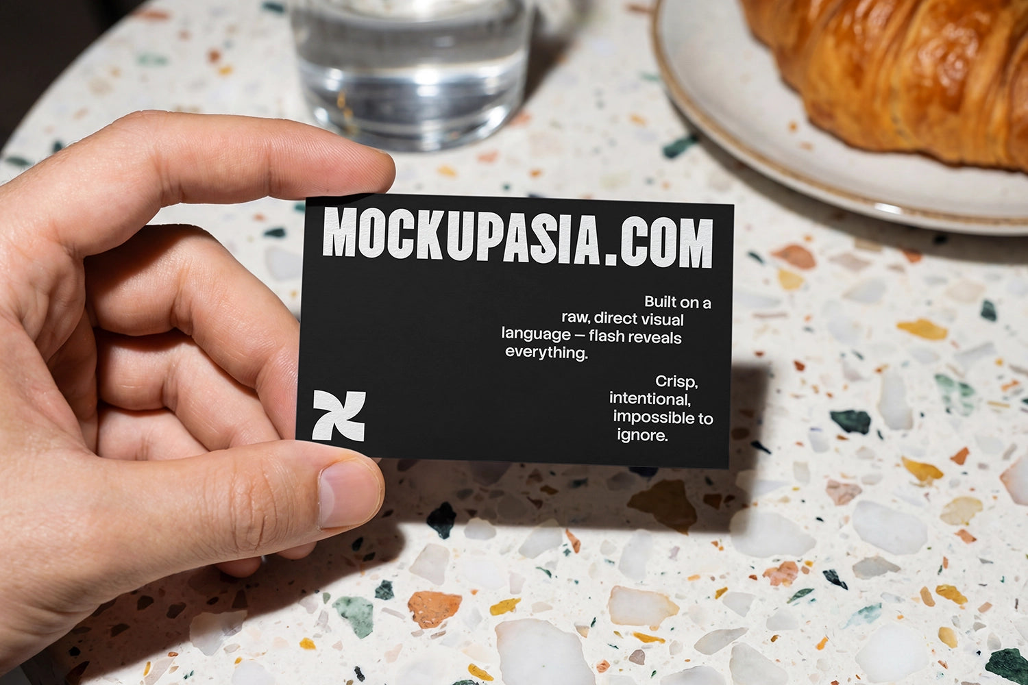 cafe business card mockup held by hand on terrazzo table with direct flash shadows