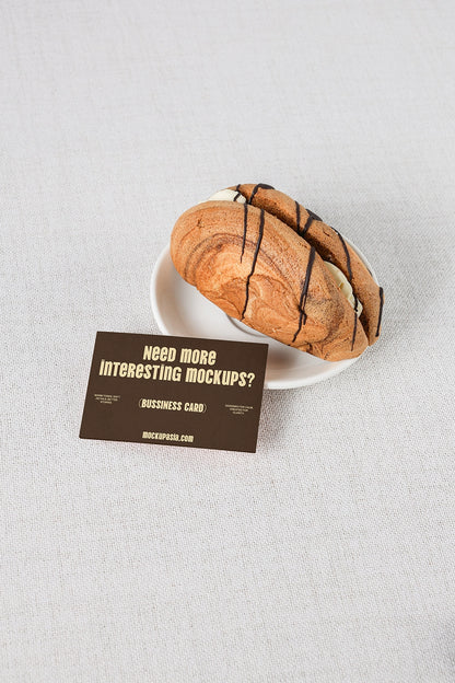 realistic business card mockup with pastry and clean neutral fabric background