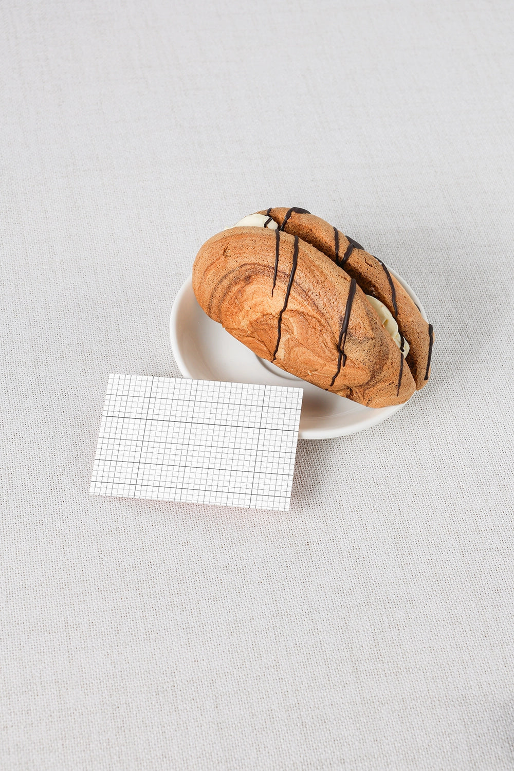 stationery mockup with business card beside bread and soft natural lighting