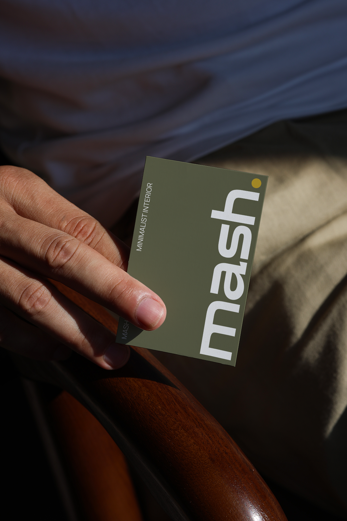 hand holding business card mockup with natural sunlight and realistic shadow on leather background