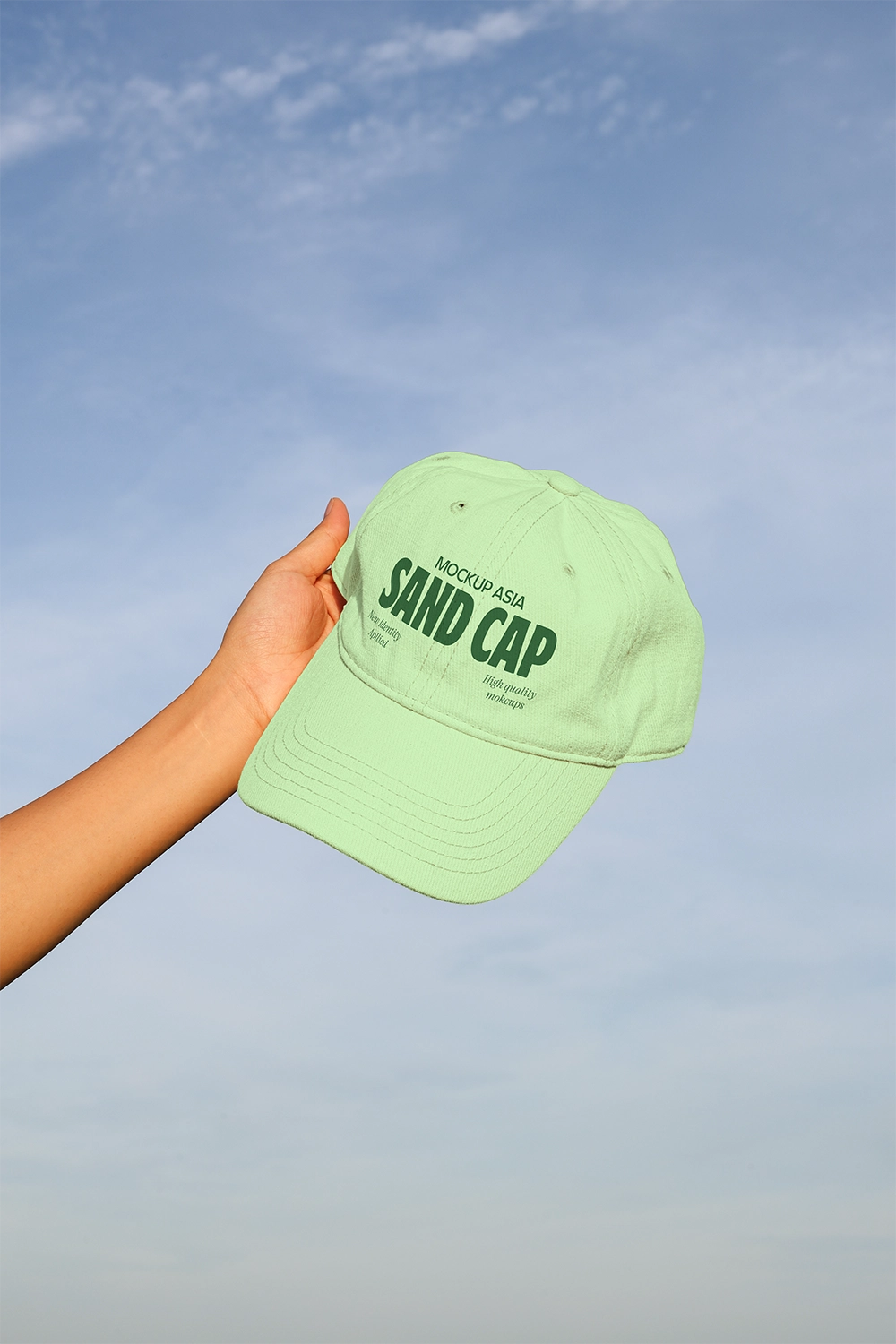sand cap mockup in hand with clean design and soft sky backdrop