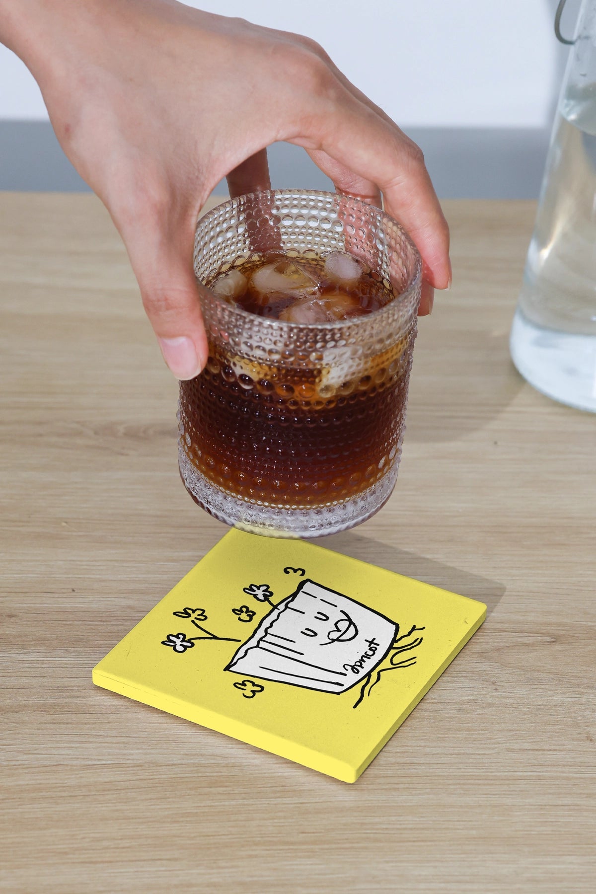 drink coaster mockup with iced beverage and hand interaction