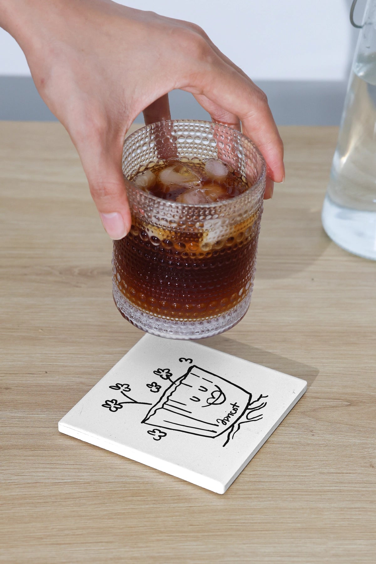 square coaster mockup with minimalist illustration under glass drink