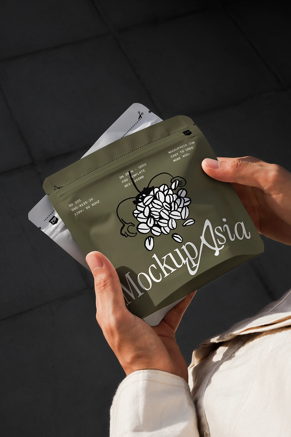 Matte olive green coffee bag mockup held by hands, featuring a professional pouch packaging design for branding.