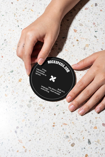 round print mockup with hands placing coaster on terrazzo surface under flash