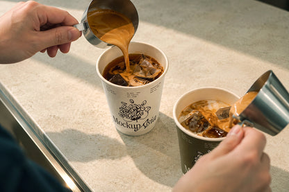 Two paper coffee cup mockups with espresso shot pour on stone counter