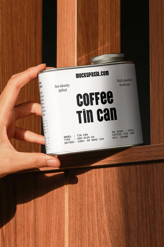 coffee tin can mockup held in hand on wooden shelf, natural light packaging presentation