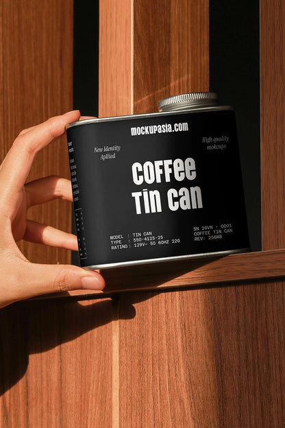coffee packaging tin mockup with hand holding container on wood background, lifestyle scene
