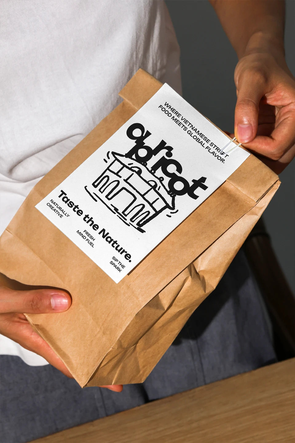 Handheld kraft coffee bag mockup with white label and minimal branding in natural light