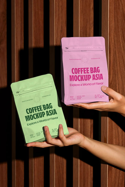 Handheld coffee bag mockup with two white pouches against wooden slat background in natural light