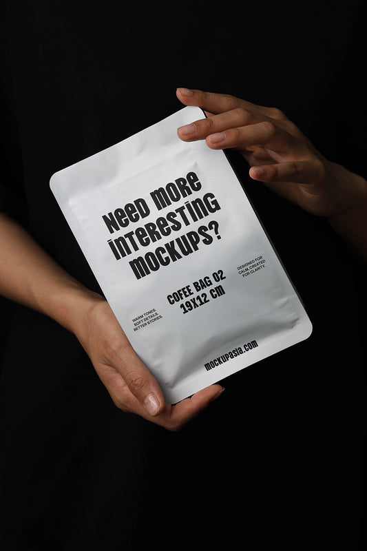 coffee pouch mockup held in hands on dark background, premium packaging presentation
