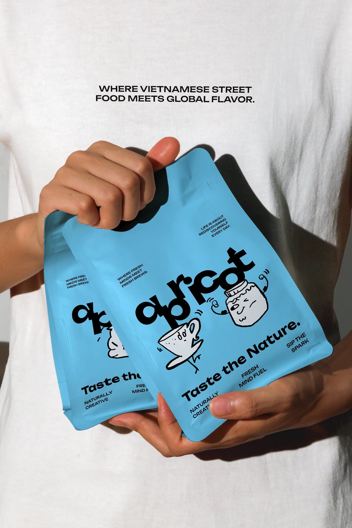 Two white coffee packaging pouches held in hand, lifestyle coffee bag mockup in natural light