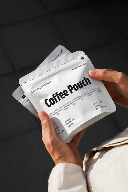 Handheld coffee pouch mockup with white packaging and clean typography in studio lighting