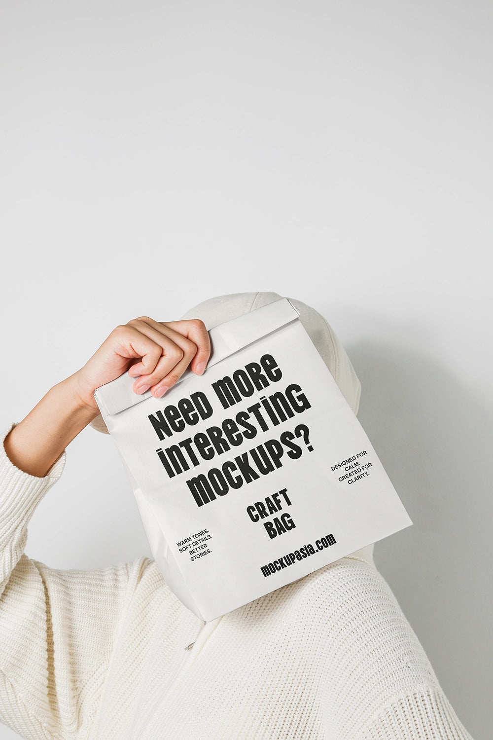 craft paper bag mockup held in hand with minimal packaging design and clean background