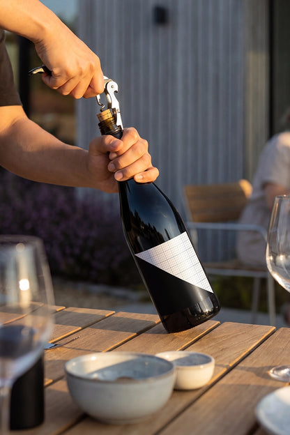 Outdoor packaging mockup with realistic glass bottle and editable design