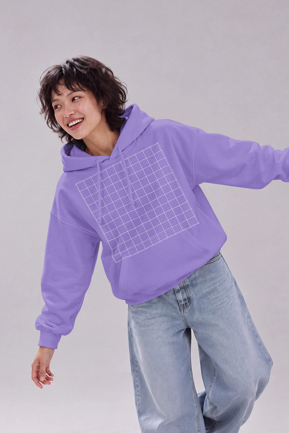 Female model wearing white hoodie mockup against studio background