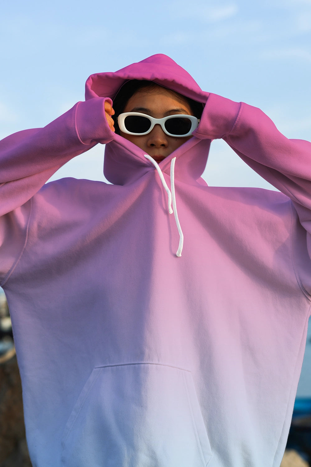 realistic hoodie mockup worn by person with sunglasses outdoor soft lighting branding presentation