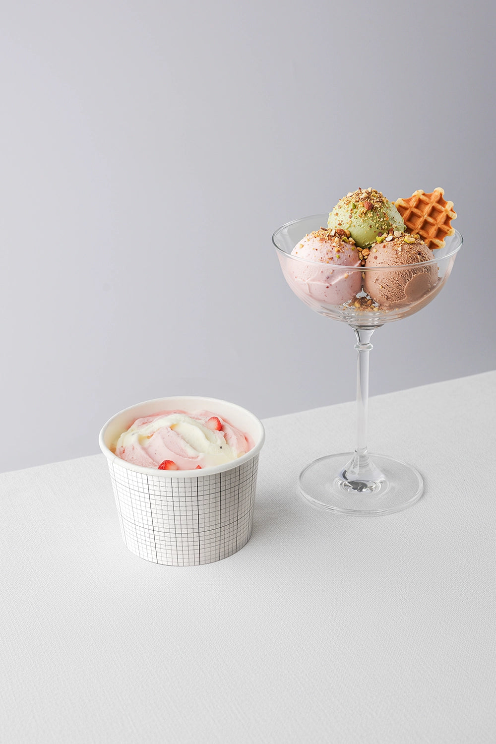 Ice cream branding mockup with cup and sundae glass featuring mixed flavor scoops