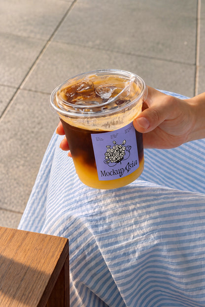 Square sticker label mockup on transparent drink cup in sunlight