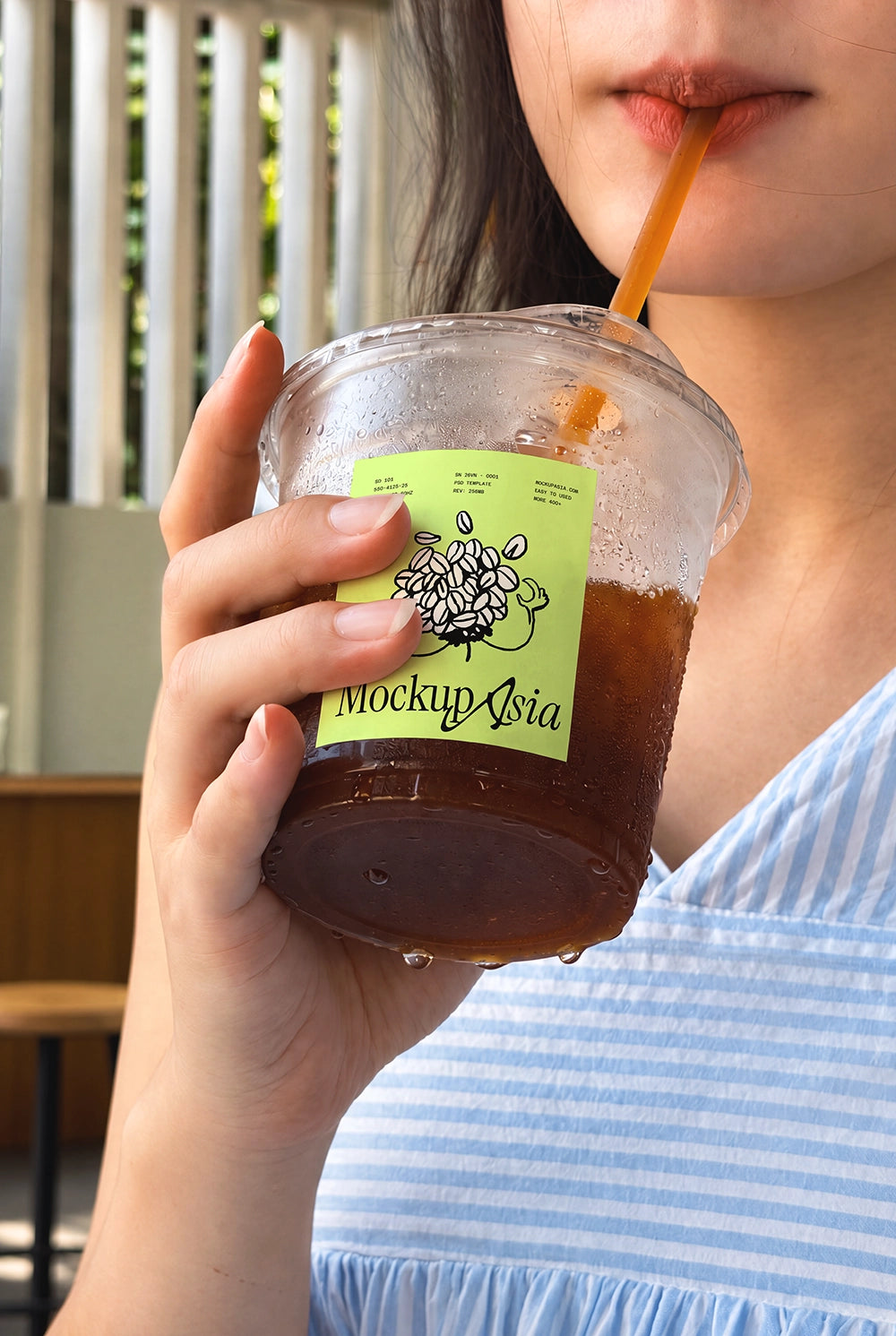 Iced coffee cup mockup with model and condensation drops in sunlight