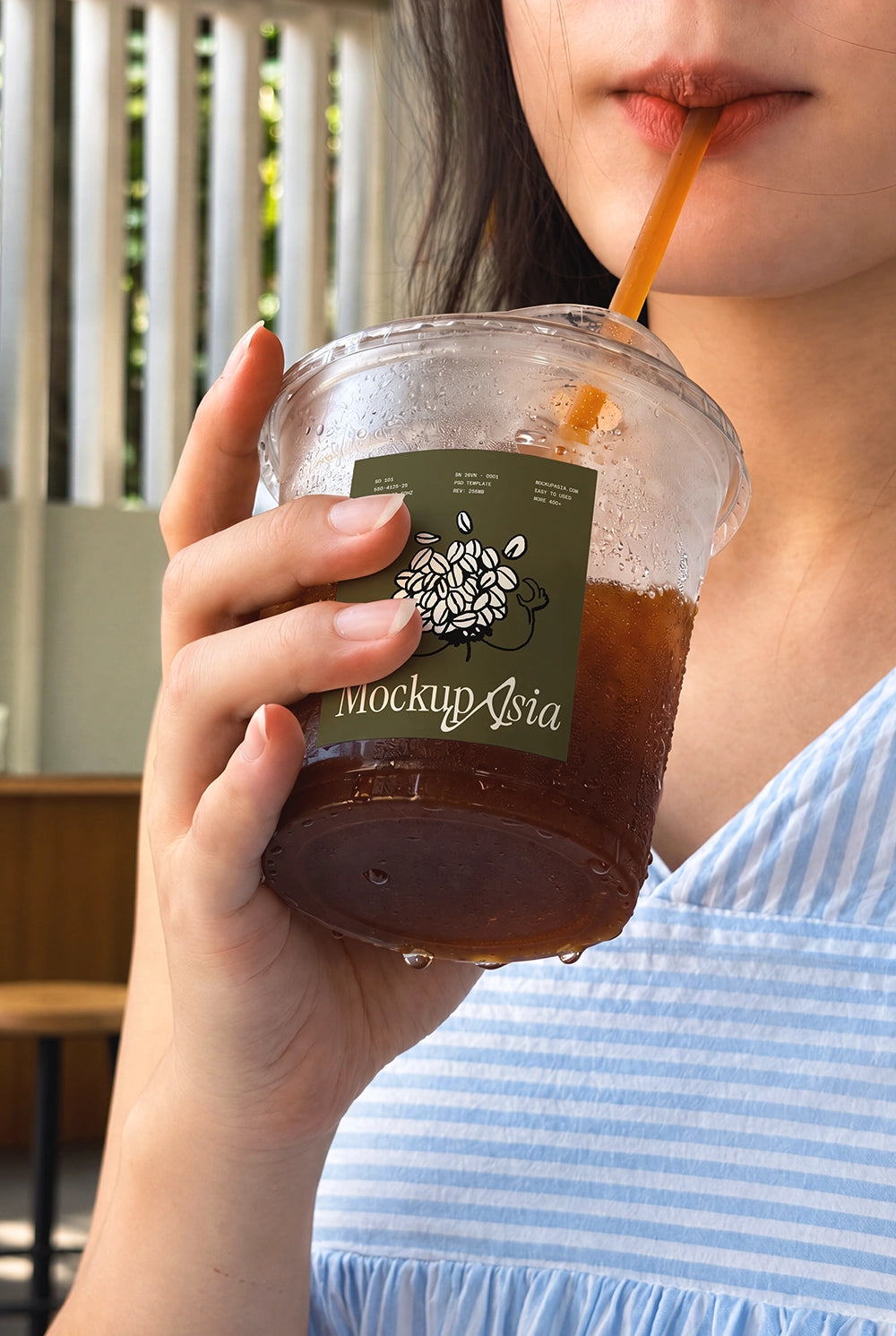 Woman drinking iced tea cup mockup blue striped dress film tone