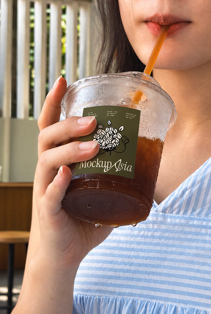 Woman drinking iced tea cup mockup blue striped dress film tone