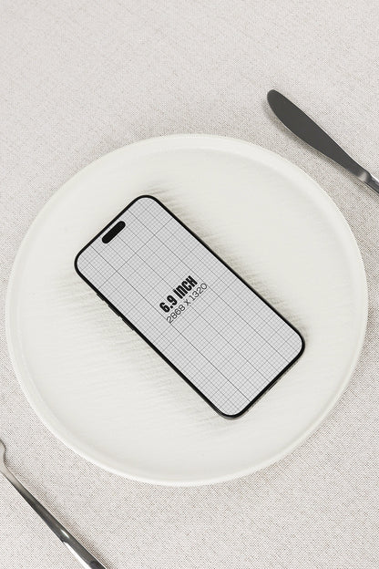 smartphone mockup on plate with minimal table setting and top view composition