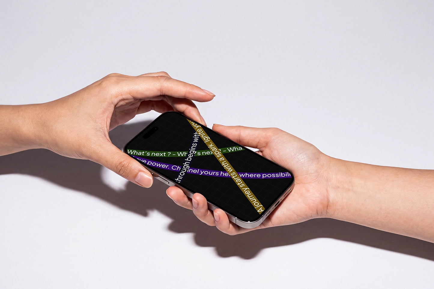 Two hands holding a smartphone against a plain white background. The phone screen displays a dark interface with yellow and purple text and a diagonal gold chain graphic.