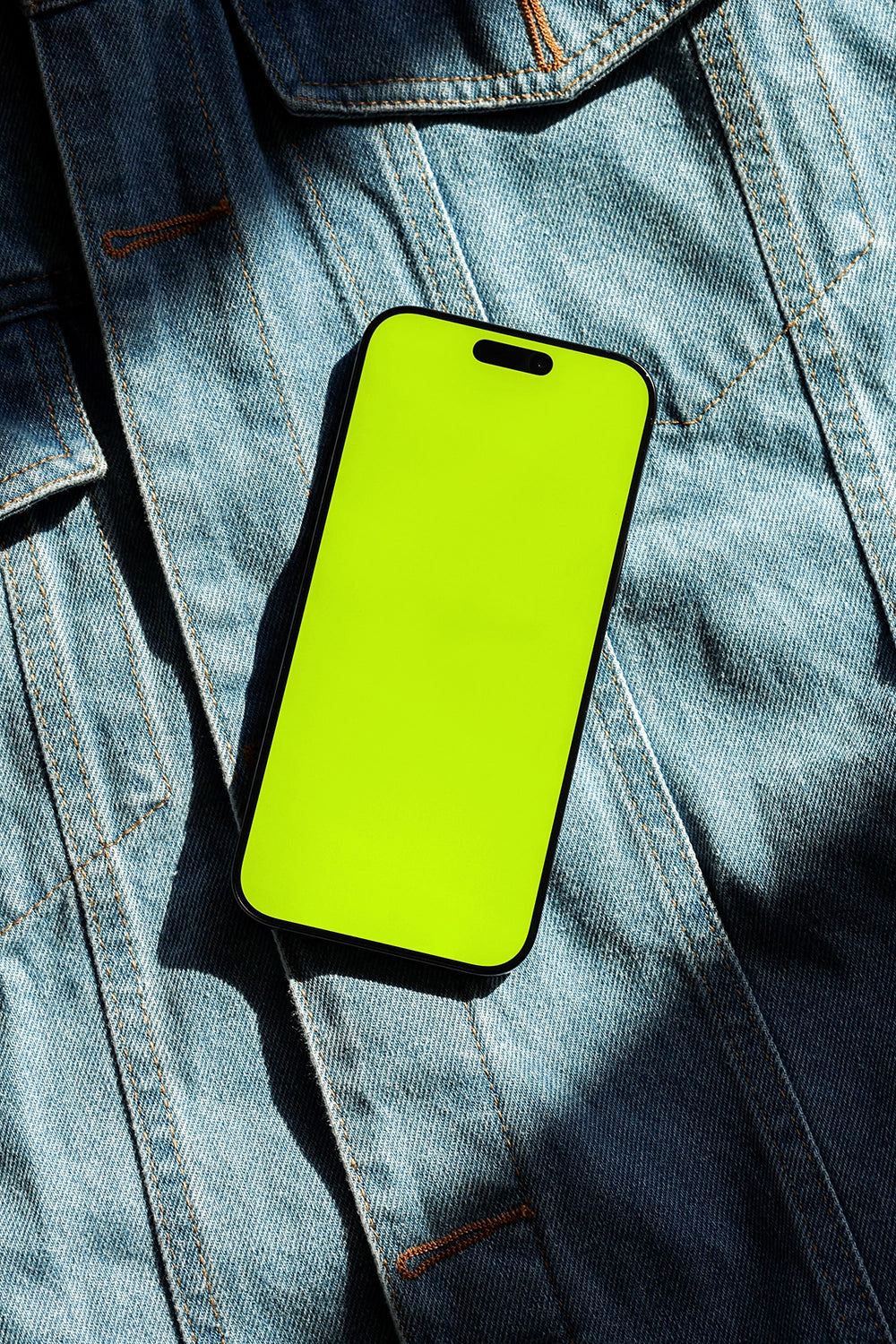 iphone screen mockup on denim texture with shadow lighting, editorial product presentation