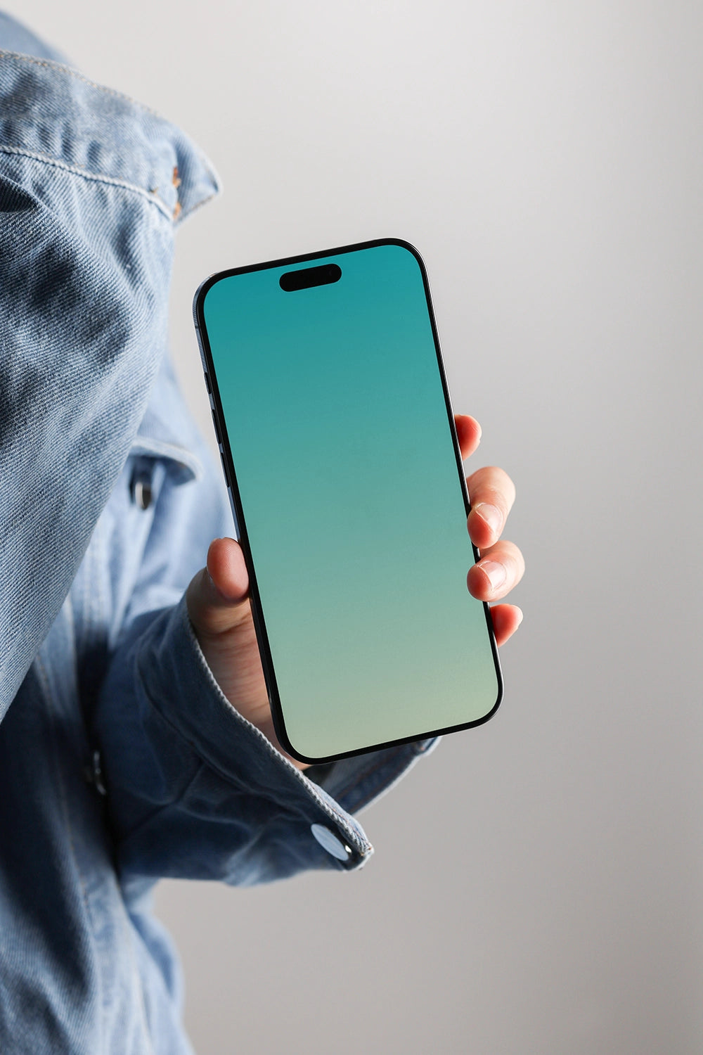 iphone screen mockup held by hand with jeans jacket, clean and stylish presentation
