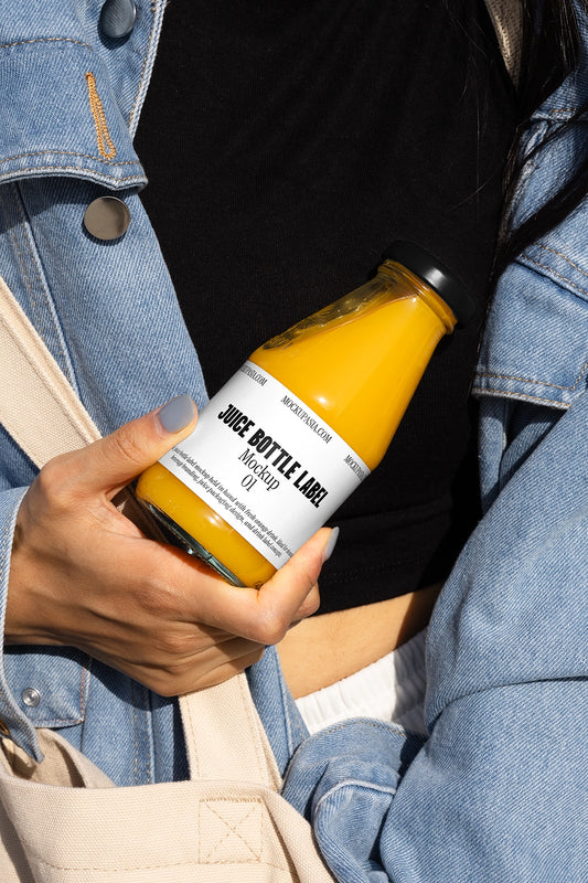 Juice bottle mockup held in hand close up outdoor lifestyle natural beverage packaging scene