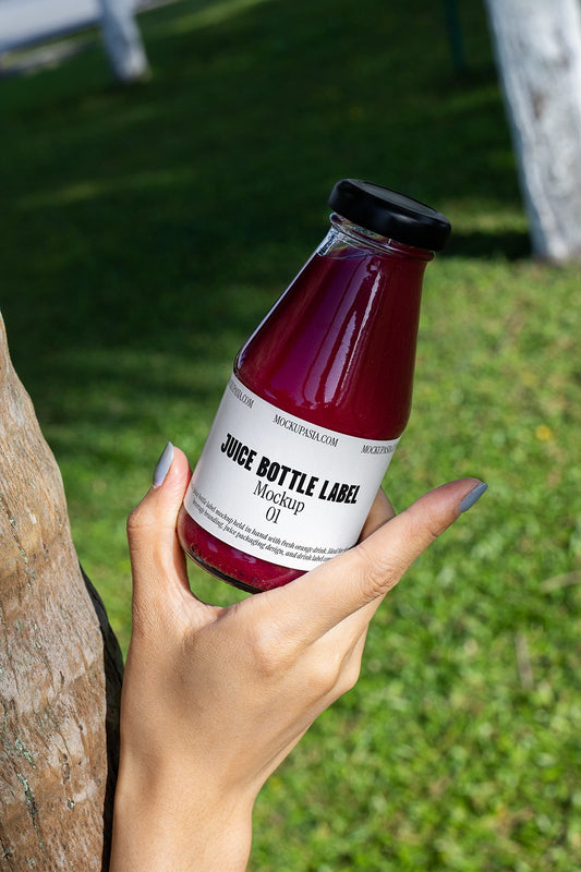 juice bottle label mockup handheld glass bottle outdoor lifestyle scene