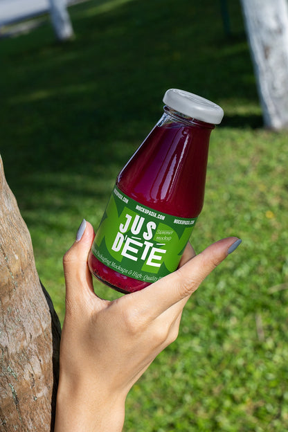 Glass juice bottle mockup close up in hand realistic outdoor packaging PSD presentation