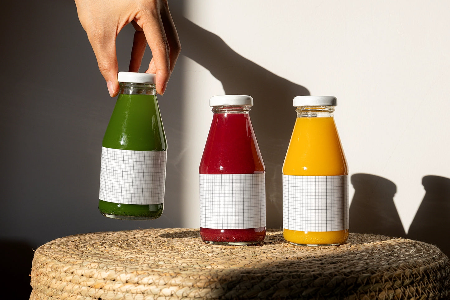 Cold pressed juice bottles mockup with blank labels for branding presentation in studio lighting