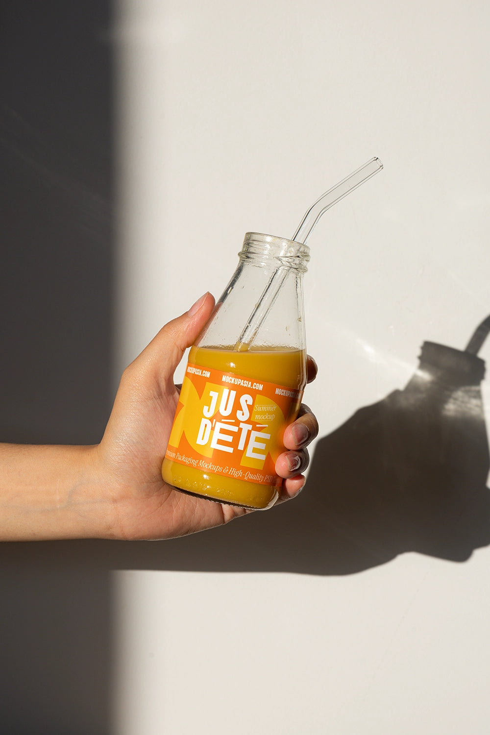 Cold pressed juice bottle mockup in hand with blank label for branding presentation