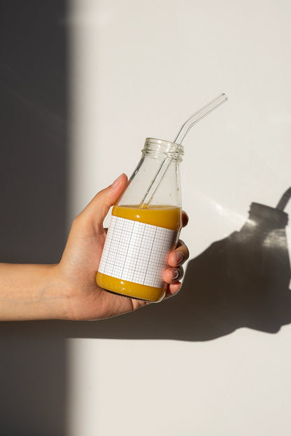 Realistic juice packaging mockup with glass bottle, straw and soft light shadow aesthetic