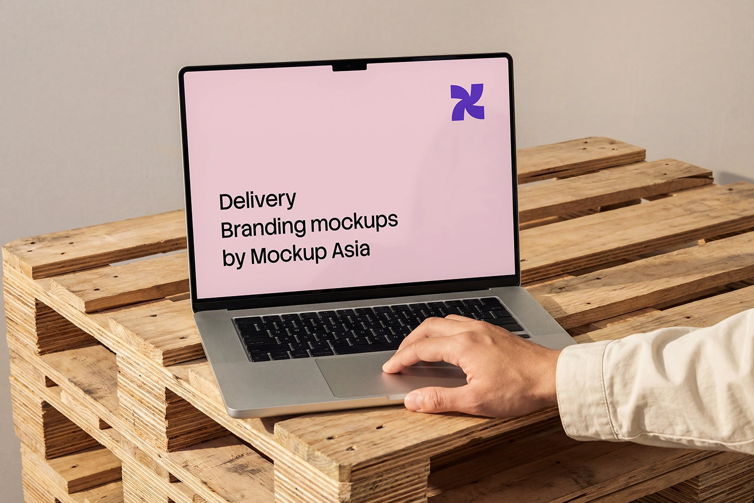 Laptop mockup on pallet desk with natural hand on trackpad

